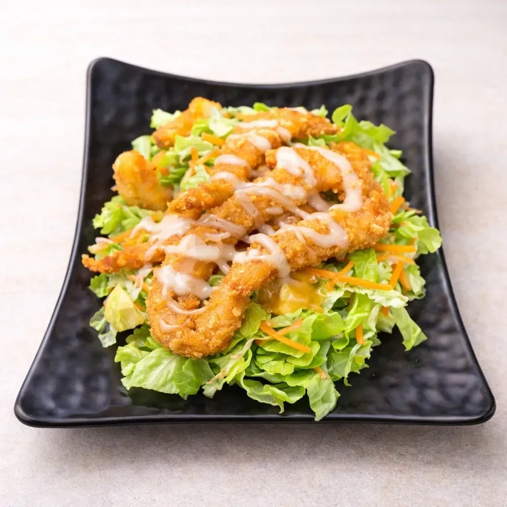 Green salad with golden fried shrimp/chicken and creamy white sauce.