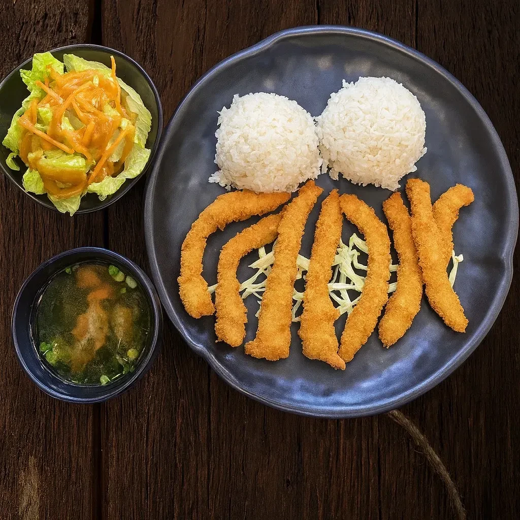 Overhead view of breaded fried food, rice, salad, and soup.