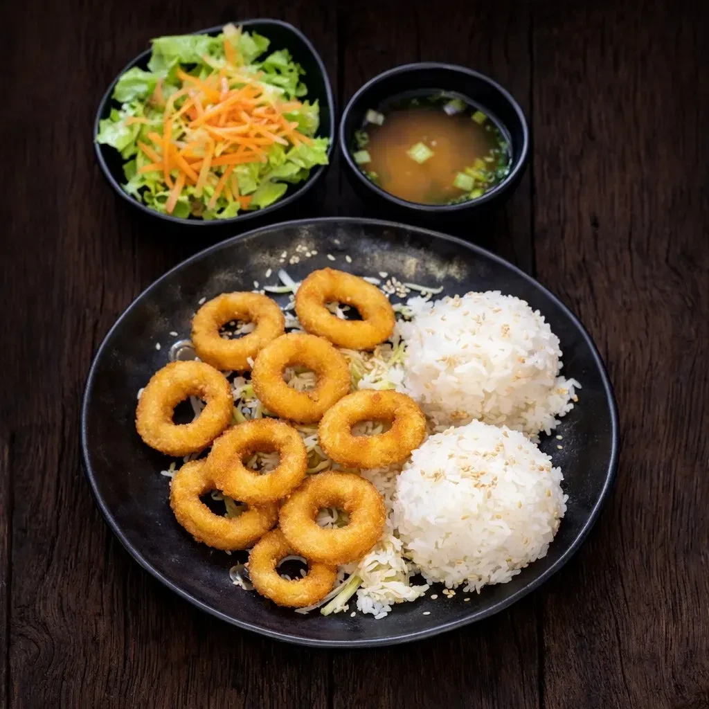 Meal of crispy fried rings, white rice, salad, and miso soup.