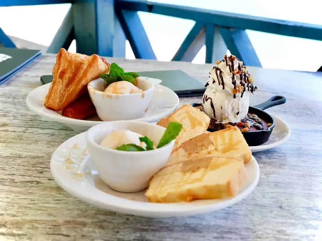 Pound cake, pastry, and skillet cookie desserts on a wooden table.