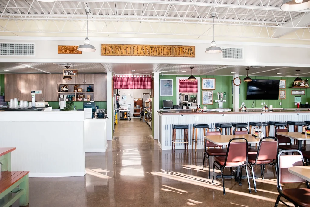 Empty casual diner interior with service counter, bar, and dining tables.