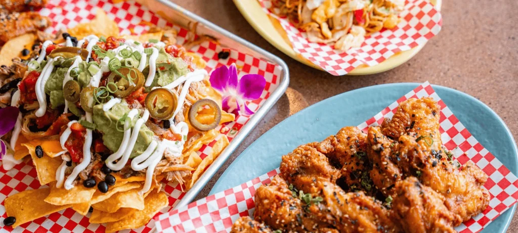 Crispy fried chicken and loaded nachos on a textured table.