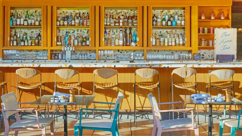 Well-stocked restaurant bar with colorful terrazzo and empty modern seating.