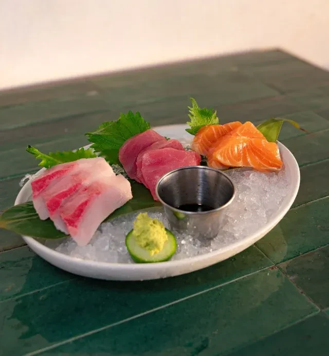 Fresh tuna, salmon, and white fish sashimi served on crushed ice.