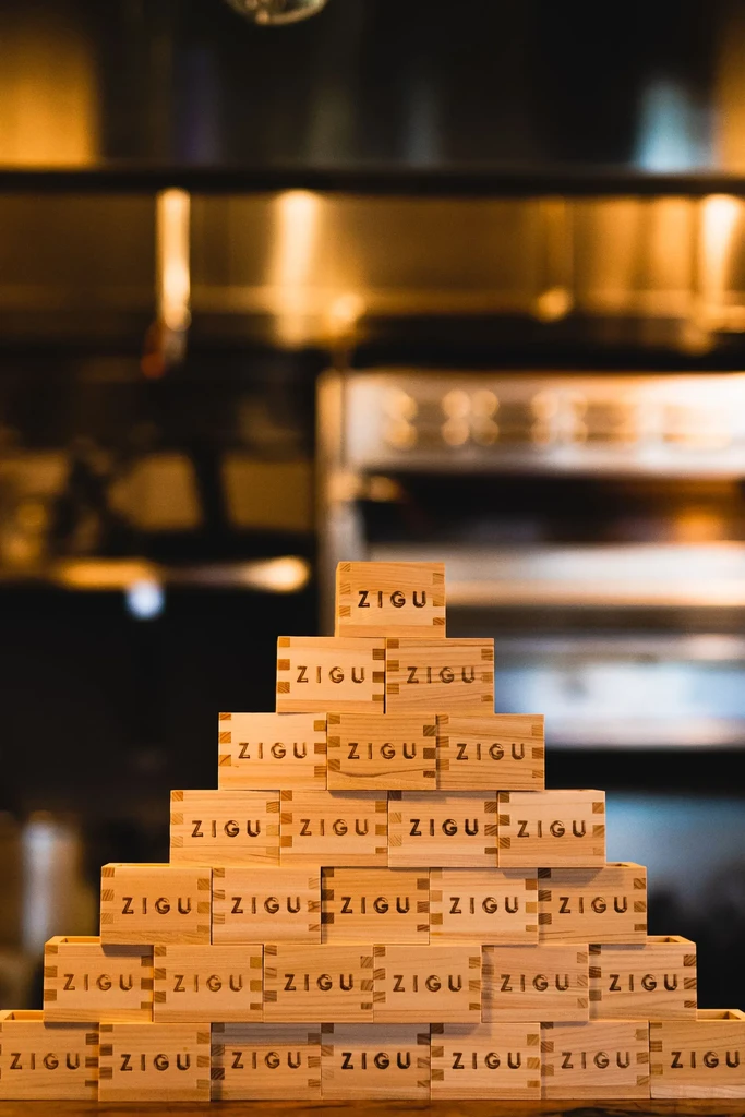 Pyramid stack of light wooden Japanese masu cups, each engraved "ZIGU."