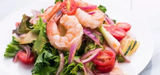 Fresh shrimp salad with lettuce, tomatoes, red onion, and green onion.