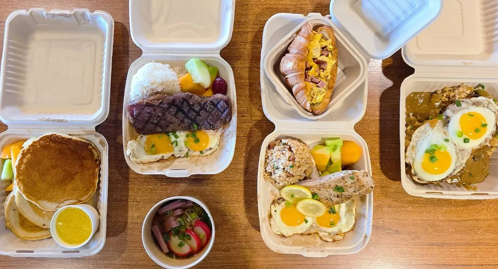 Six open takeout containers filled with diverse breakfast and brunch dishes.
