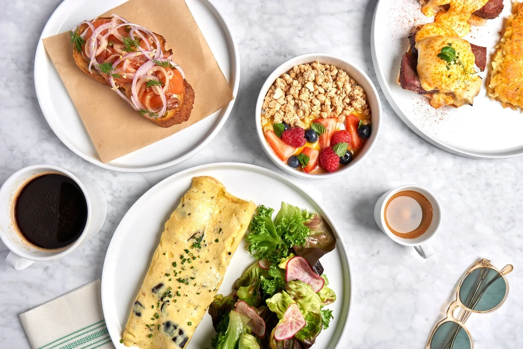 Overhead shot of a marble table laden with various brunch dishes.
