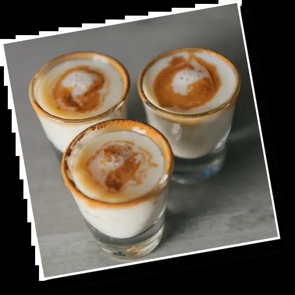 Three small clear glasses with creamy drinks, caramel swirls, coated rims.