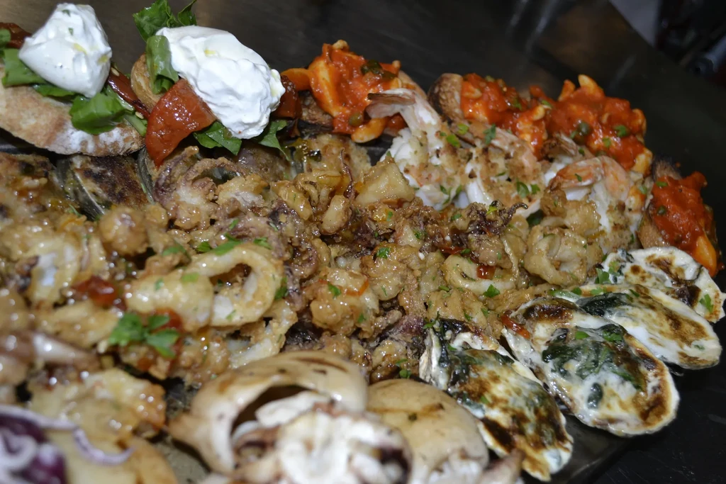 A close-up of a platter of mixed seafood and appetizers.
