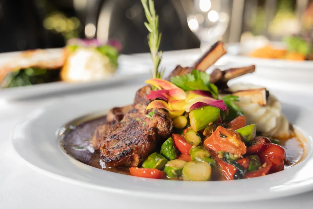 Plate of lamb chops, vegetables, and mashed potatoes at a restaurant.