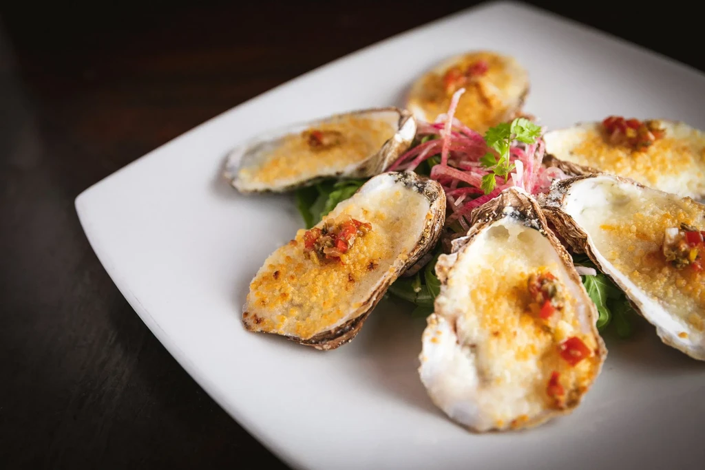 Baked oysters on the half shell with breadcrumbs and salsa.