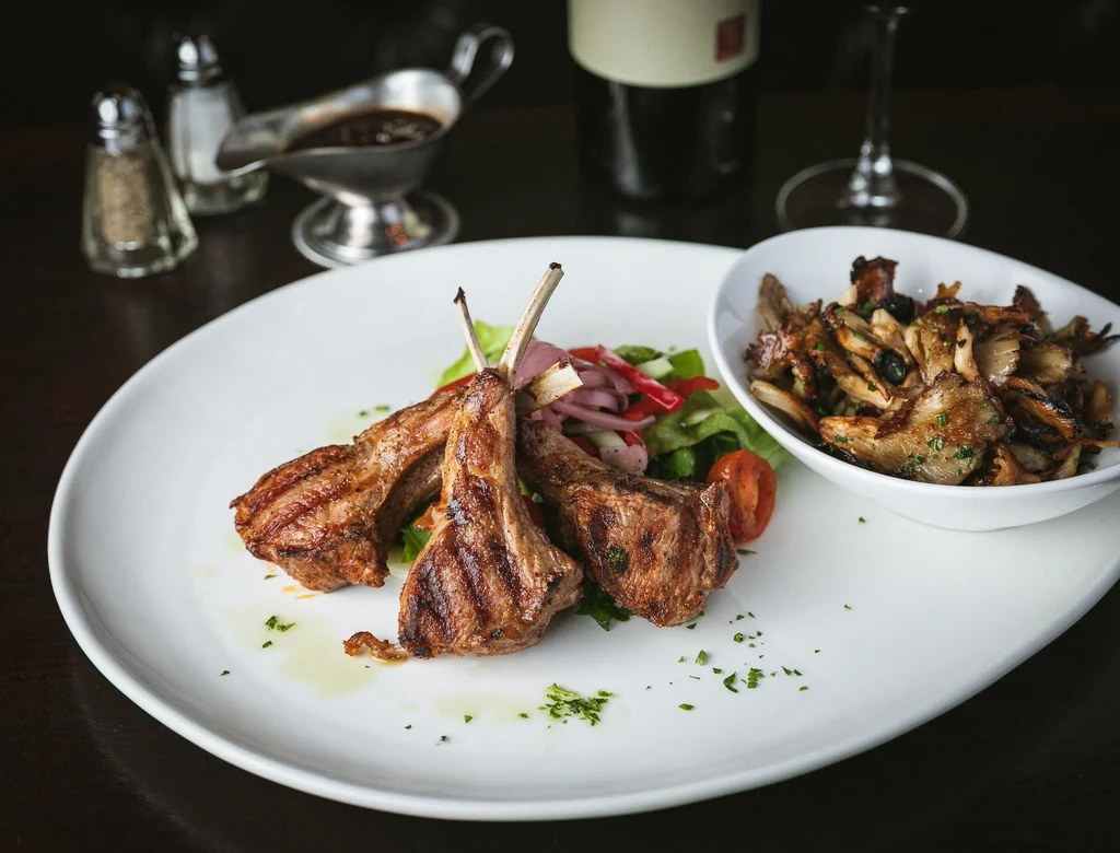 Grilled lamb chops with roasted mushrooms and a small salad.