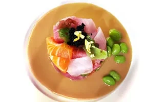 Overhead view of a colorful tuna tartare dish with edamame beans.