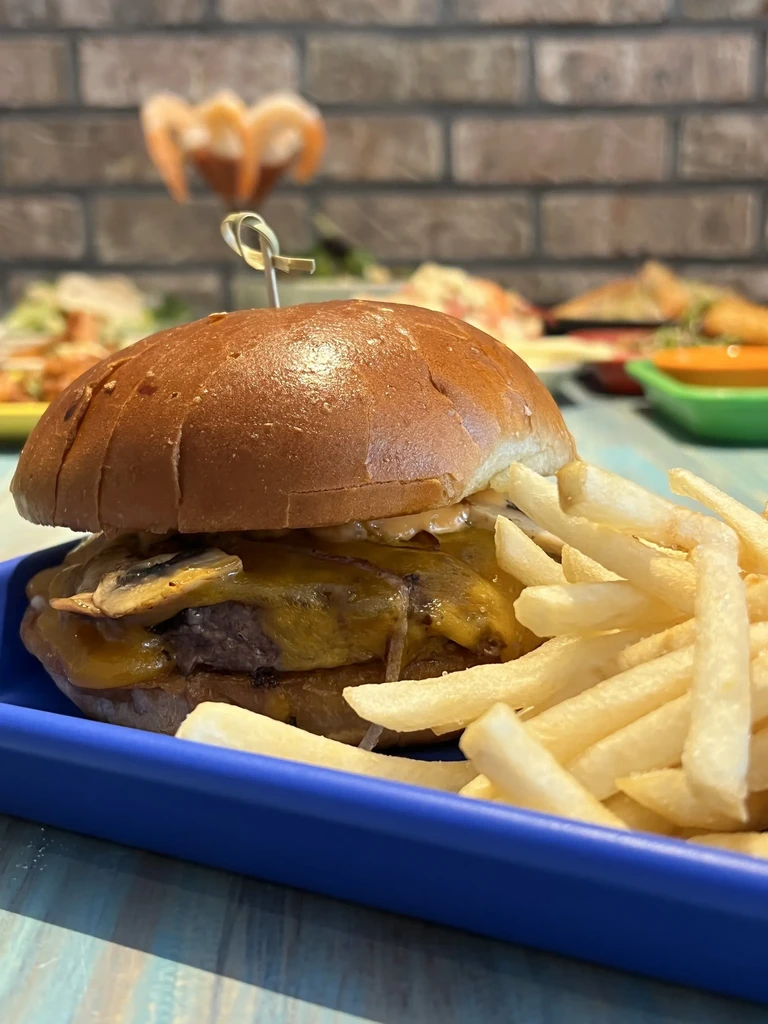 Mushroom Swiss burger and fries on a blue tray.