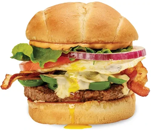 Gourmet burger with runny egg yolk, bacon, jalapeños, and beef patty.