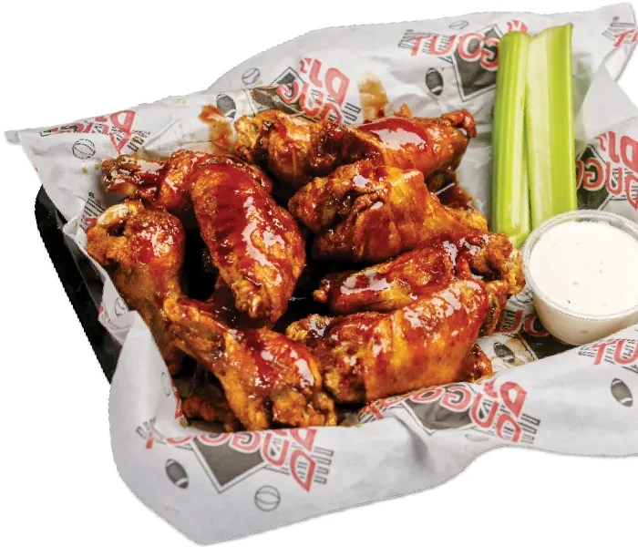 Plastic basket of glistening chicken wings, celery, and white dipping sauce.