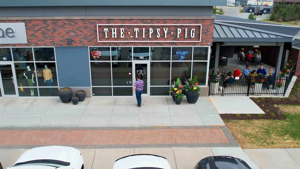 Elevated view of 'THE TIPSY PIG' restaurant and lively outdoor patio.