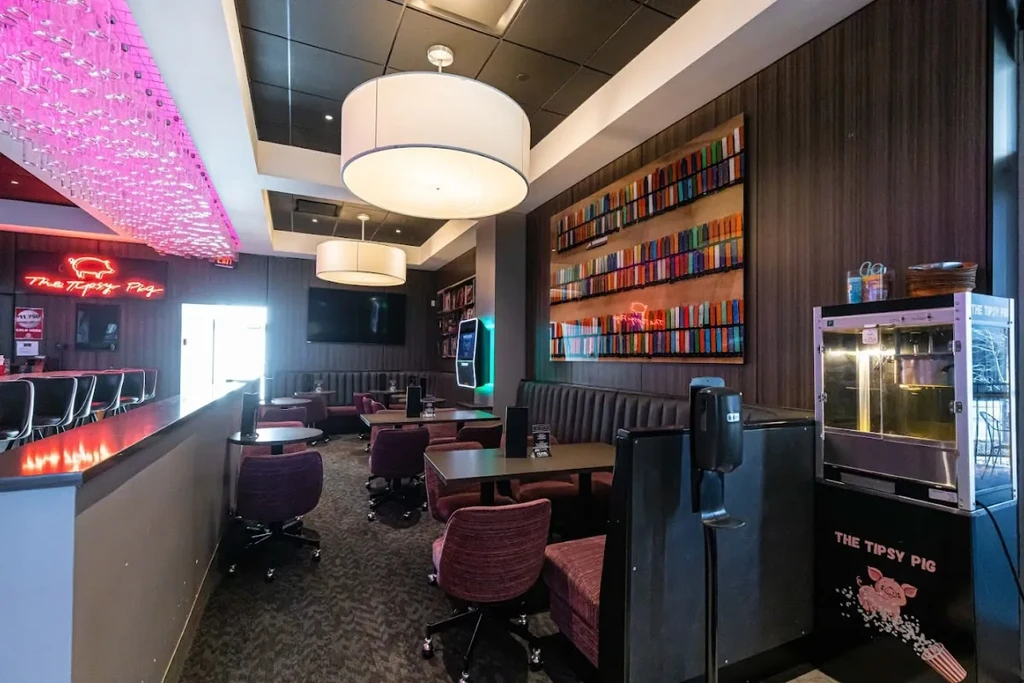 Interior of "The Tipsy Pig" restaurant bar with pink neon sign.