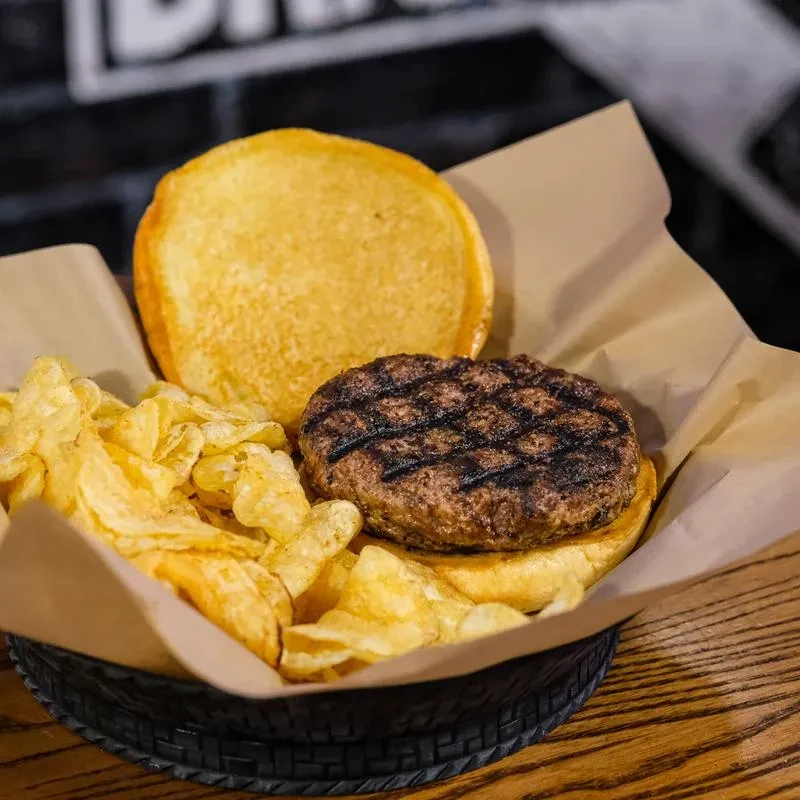 Close-up of a deconstructed burger and chips in a basket.