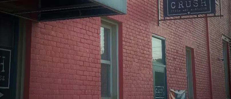 Red brick building exterior with 'Crush Pizza and Alehouse' sign.