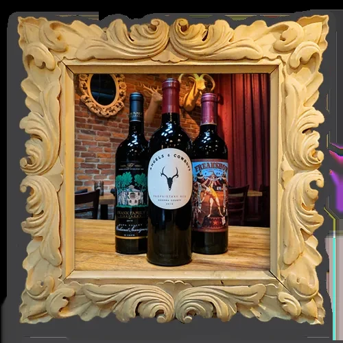 Three wine bottles framed against a rustic bar interior with deer head.