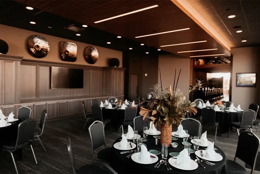 Formal dining hall interior with elegantly set tables and warm lighting.