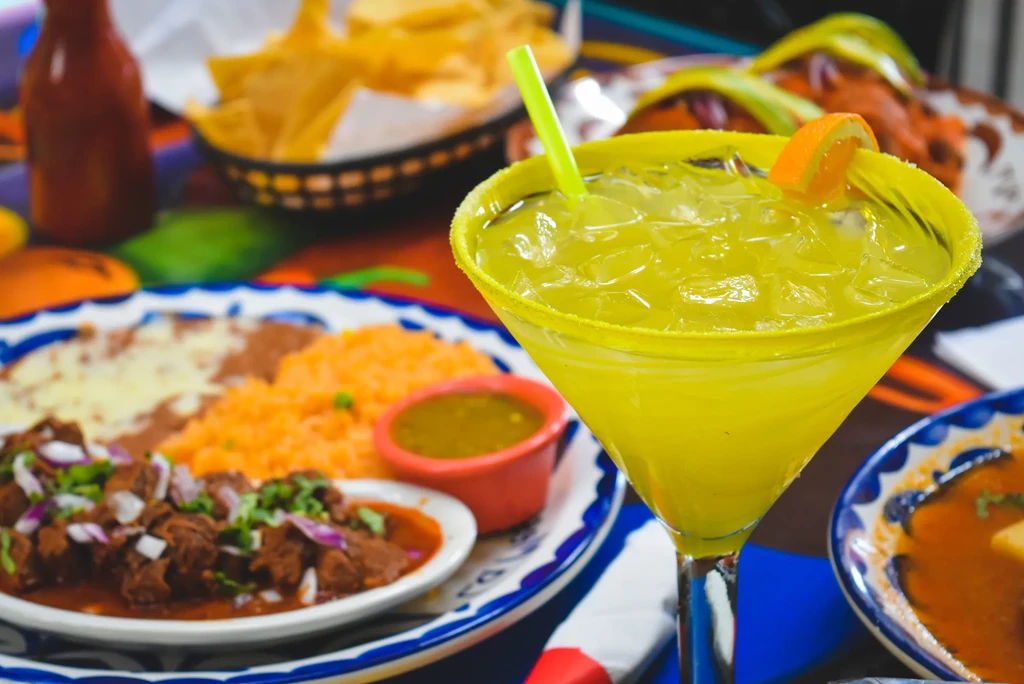 Close-up: Margarita with sugared rim, and a plate of colorful Mexican food.