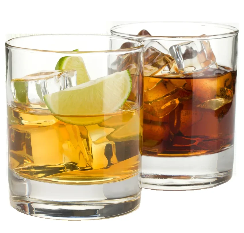 Two tumblers with amber and brown drinks, ice, and a lime.