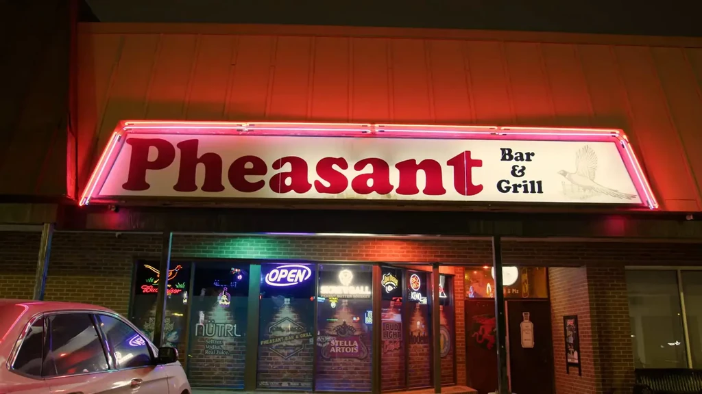 Pheasant Bar & Grill exterior brightly lit at night with neon.