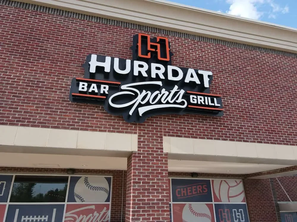HURRDAT BAR Sports GRILL's red brick exterior with sign and decals.