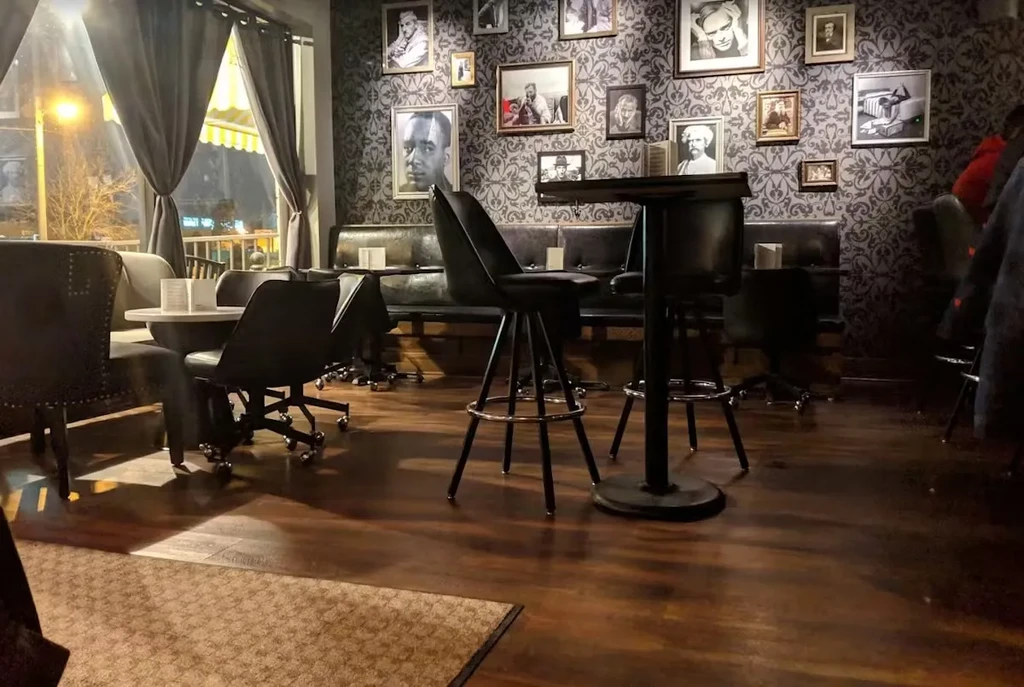 Dimly lit, sophisticated bar interior with vintage decor and varied seating.