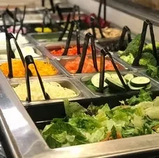 A vibrant, well-stocked self-service salad bar with fresh produce.