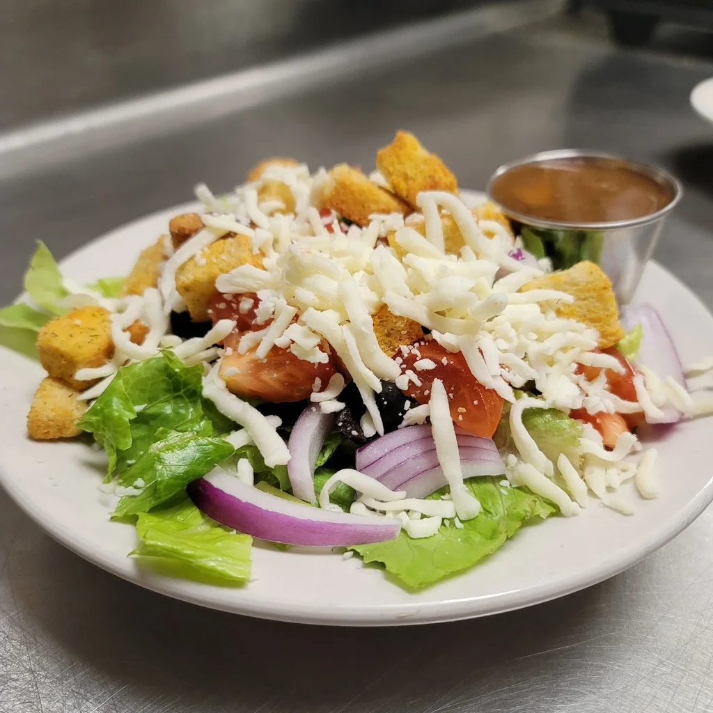 Fresh garden salad with lettuce, tomato, onion, olives, cheese, croutons.