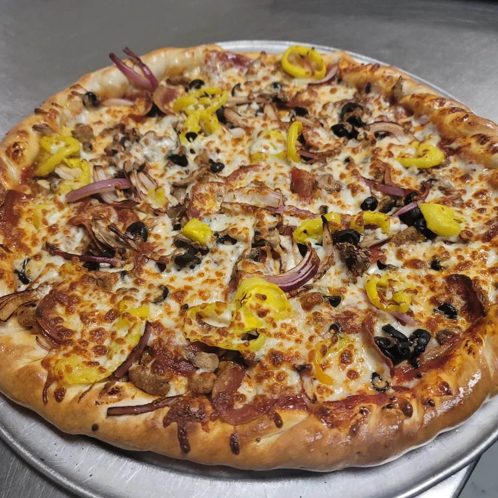 Pizza with melted cheese, olives, peppers, red onion, sausage, and mushrooms.