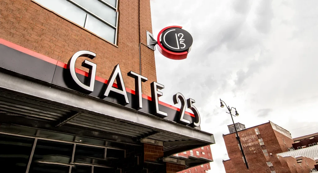 Brick building exterior featuring large silver 'GATE 25' signs.