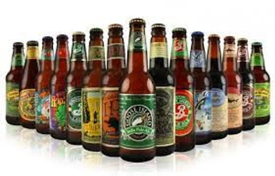 V-shaped arrangement of diverse beer bottles; Goose Island bottle prominent.