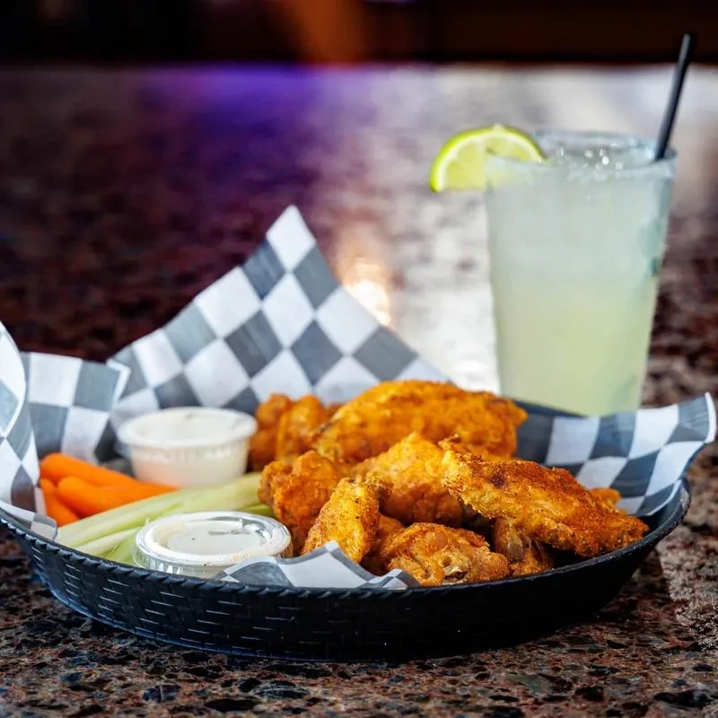 Crispy golden chicken wings, veggies, dipping sauces, and a margarita.