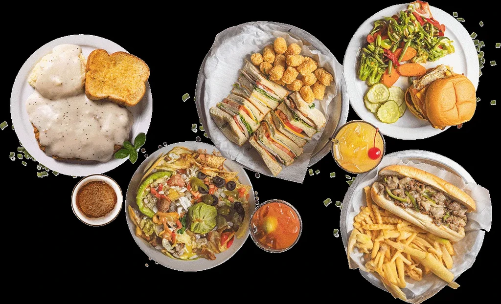 Overhead view of various American diner-style dishes and drinks on black.
