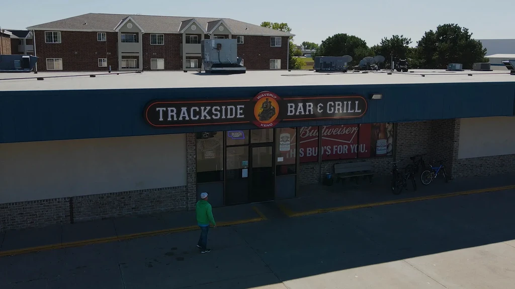 Blue Trackside Bar & Grill exterior with person walking towards entrance.