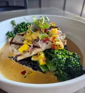 Grilled white fish, mango salsa, black rice, broccoli, and sauce.