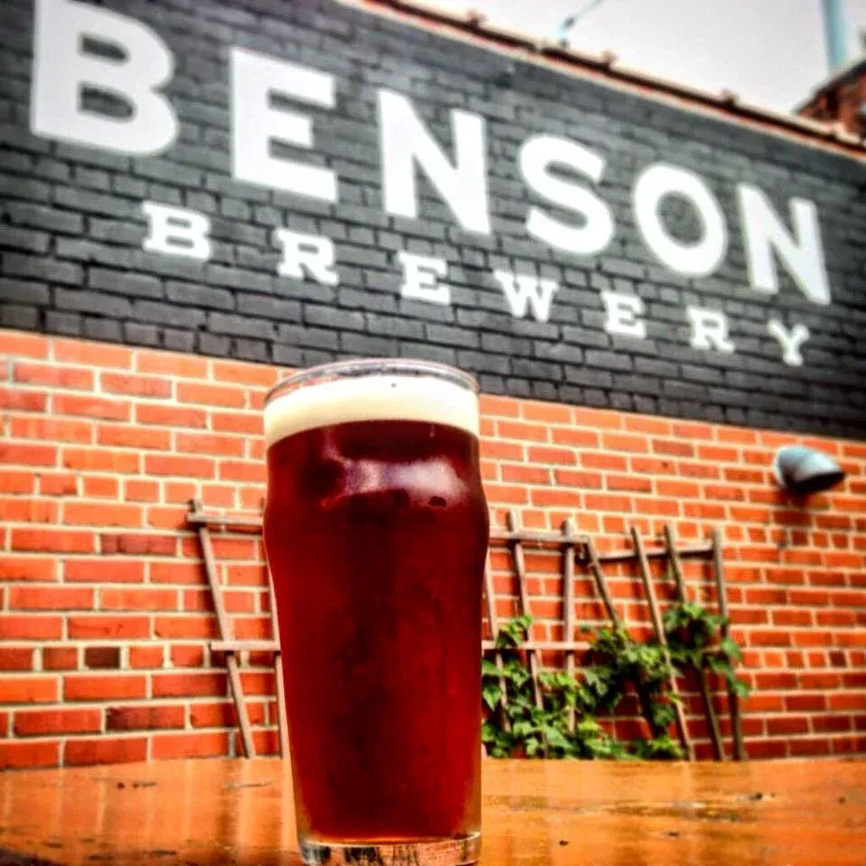 Dark beer in cold glass with frothy head, Benson Brewery.