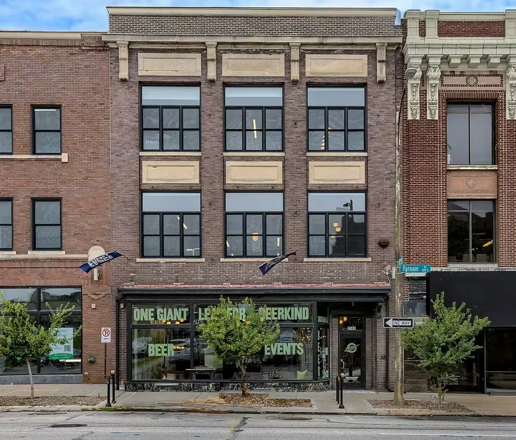 Urban brick brewery with 'ONE GIANT LEAP FOR BEERKIND' on its windows.