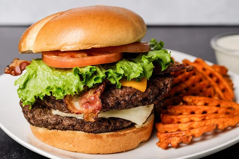 Double-patty bacon cheeseburger, waffle-cut sweet potato fries, and dipping sauce.