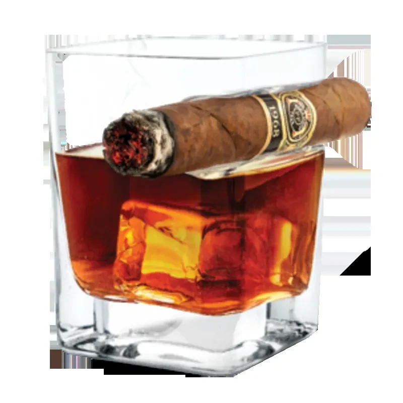 Lit cigar rests on a glass of amber liquid with ice.