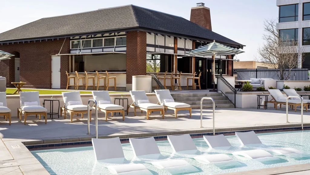 Modern outdoor bar and swimming pool with lounge seating.