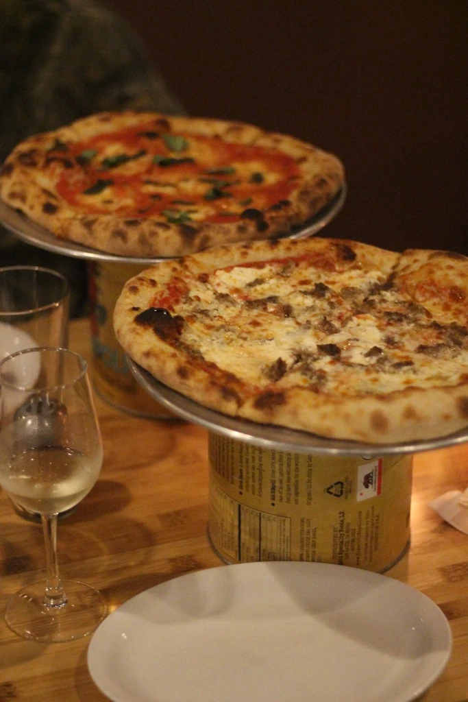 Two pizzas on repurposed California bear logo can stands.