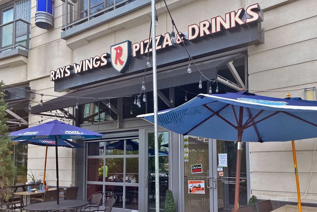 Modern Rays Wings Pizza & Drinks restaurant exterior with patio seating.