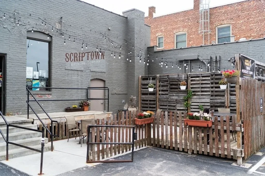Scriptown Brewing Company exterior with empty, string-lit, fenced patio.