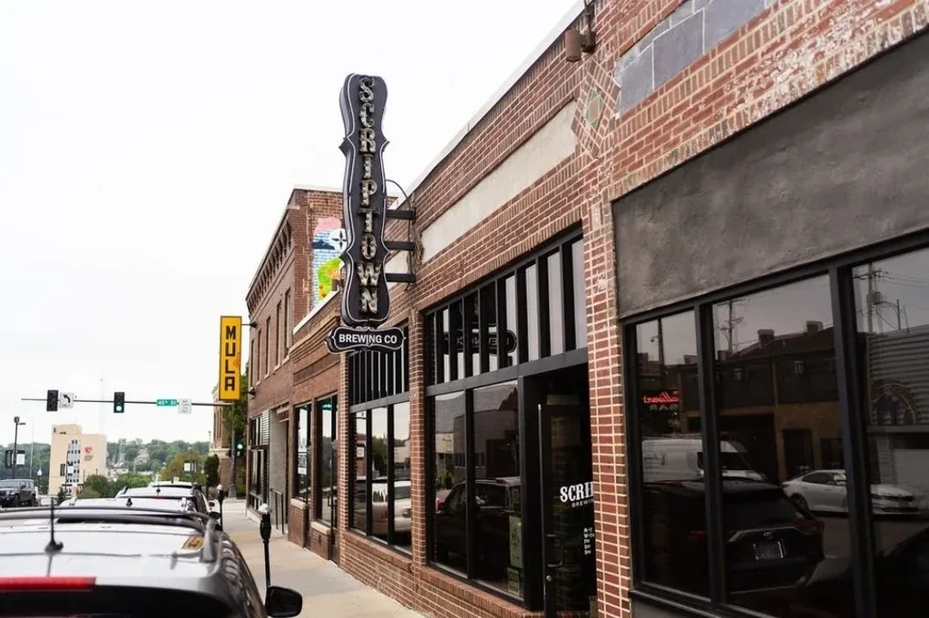 Vintage neon "SCRIPTOWN BREWING CO" sign on a multi-story brick building.